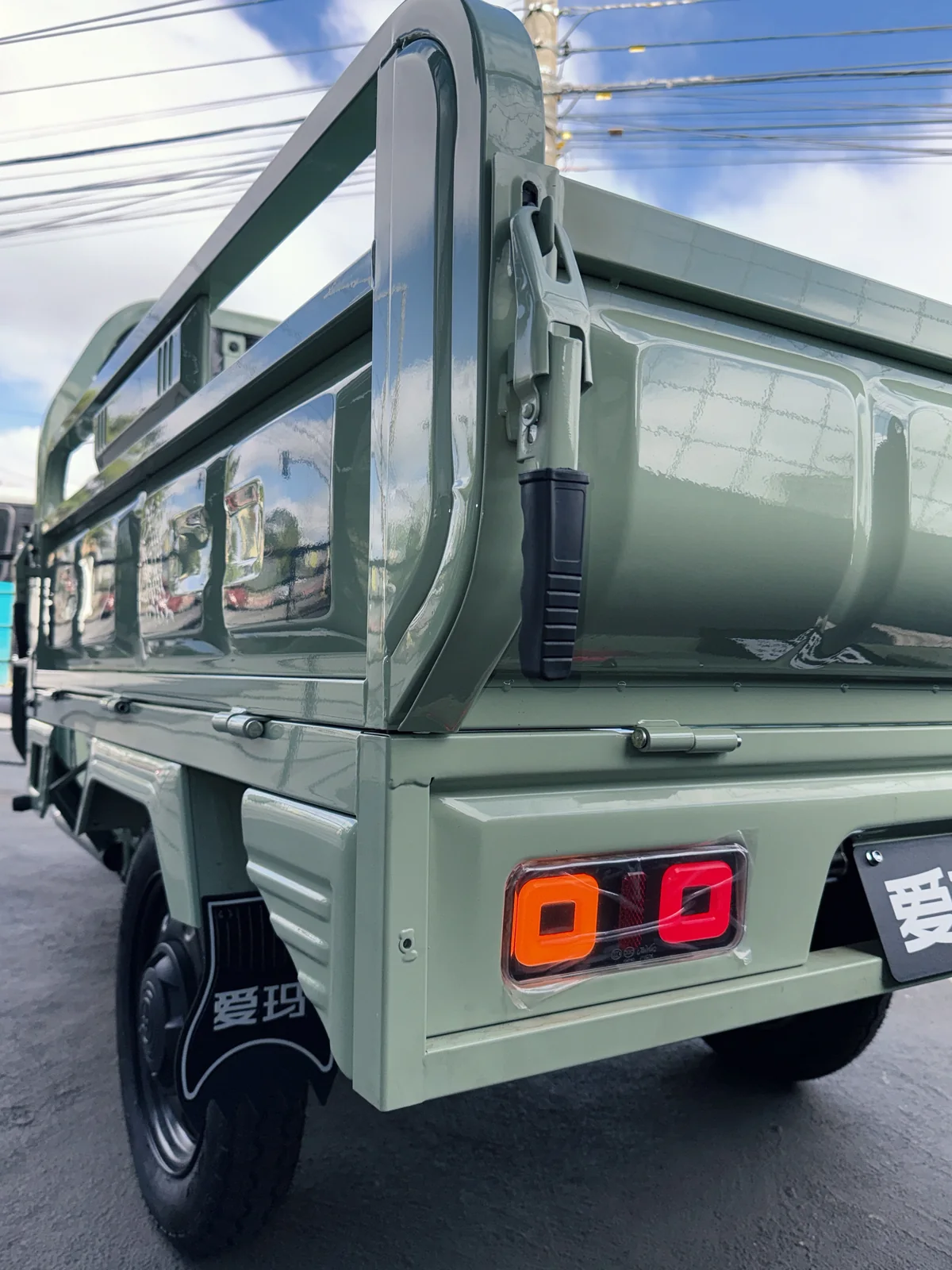 Vista traseira do AIMA Tank verde, com caçamba e lanternas